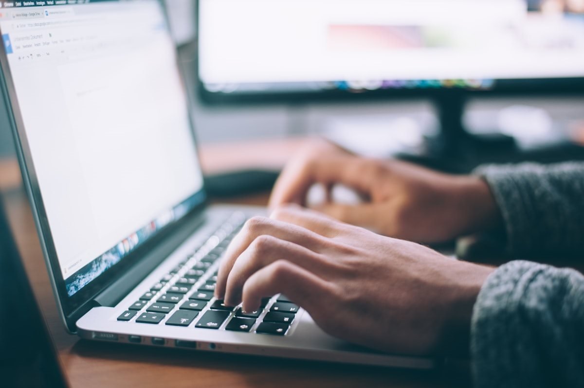 Hands typing on a laptop during data entry practice